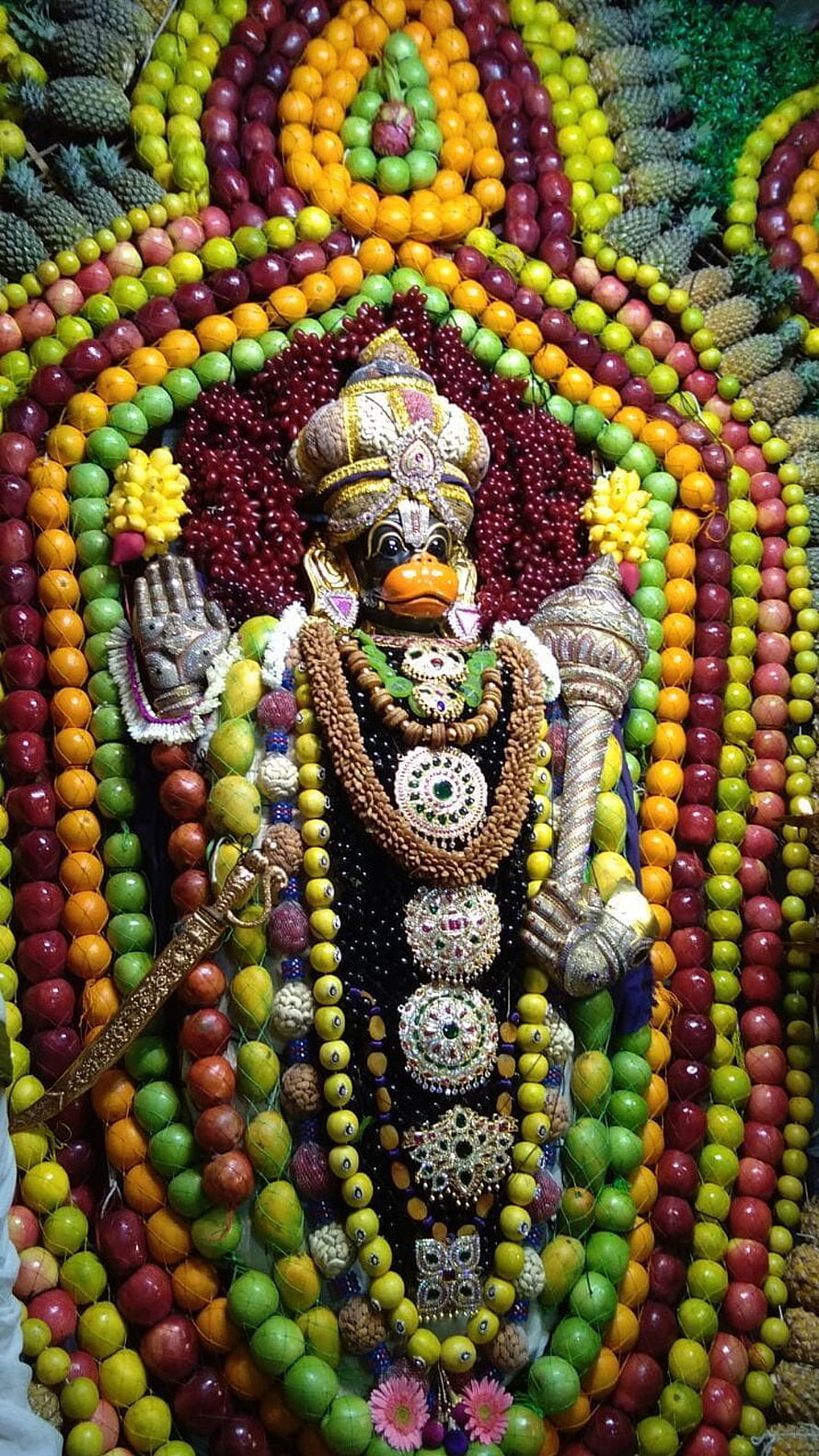 Anjaneya Swamy deity adorned in ornate jewelry and surrounded by vibrant fruit offerings HD phone wallpaper