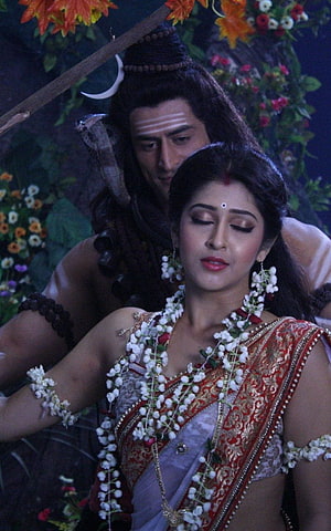 Lord Shiva and Parvati in traditional Indian attire with jasmine garlands and sacred markings HD phone wallpaper