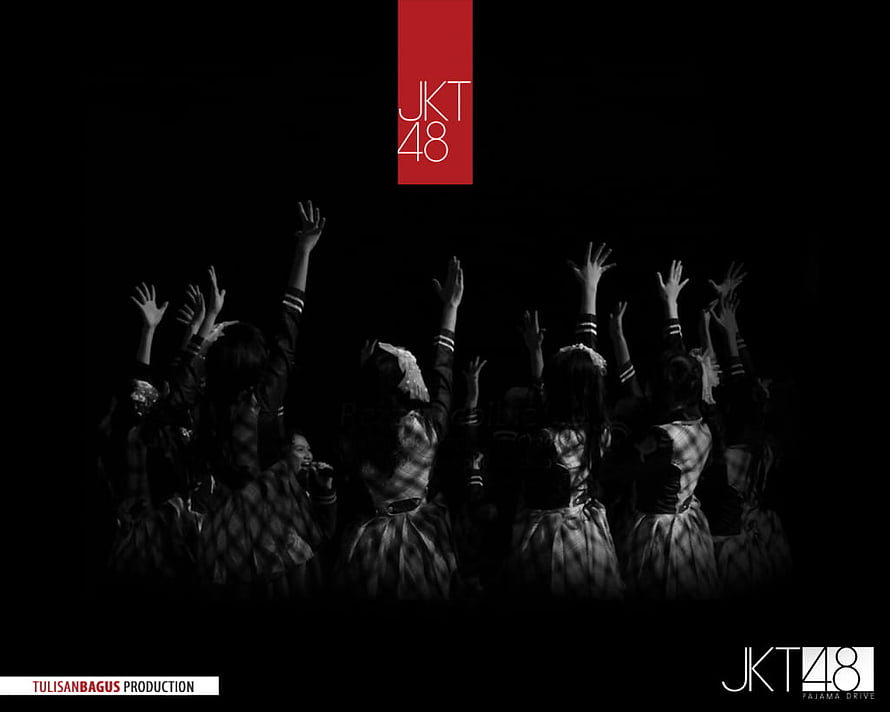 JKT48 Members Performing on Stage with Raised Hands in Dramatic Black and White Lighting HD wallpaper