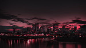 Dramatic Red Tinted City Skyline at Night with Water Reflections HD wallpaper