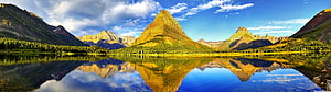 Majestic Mountain Peaks Reflected in a Calm Alpine Lake Under a Blue Sky HD wallpaper