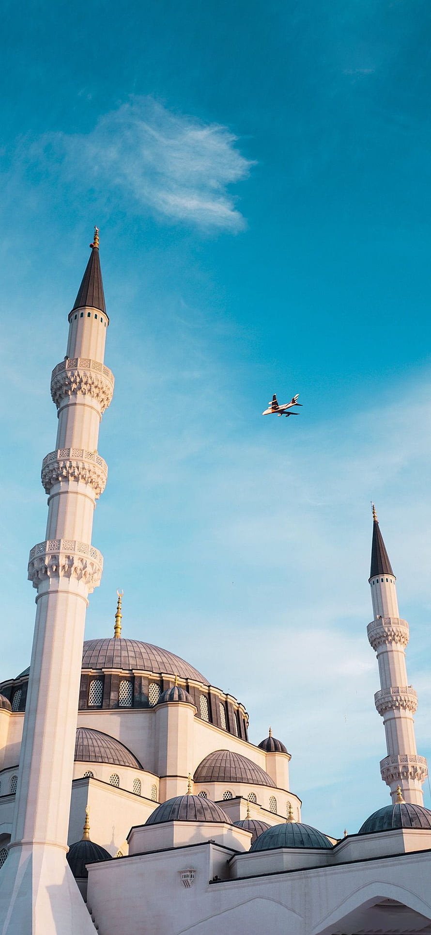 Sultan Ahmed Mosque in Istanbul with a jet flying overhead against a clear blue sky HD phone wallpaper