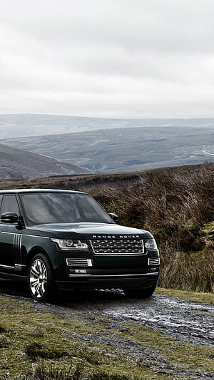 Black Range Rover SUV on a misty moorland trail with rolling hills in the background HD phone wallpaper