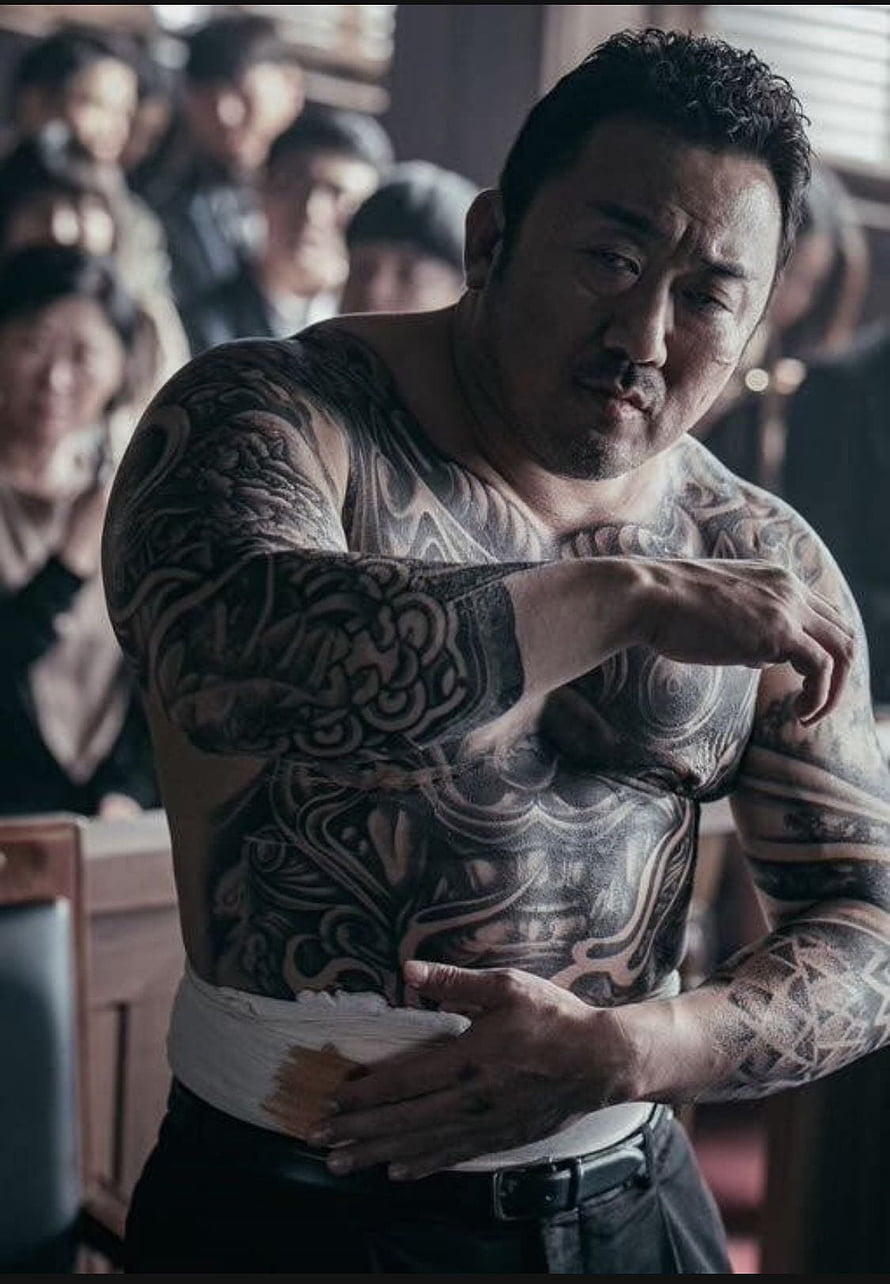 Ma Dong Seok shirtless with full body tattoos and bandaged abdomen in dramatic cinematic scene HD phone wallpaper