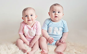 Adorable Twin Babies in Matching Pink and Blue Outfits Sitting on a Fluffy Rug HD wallpaper