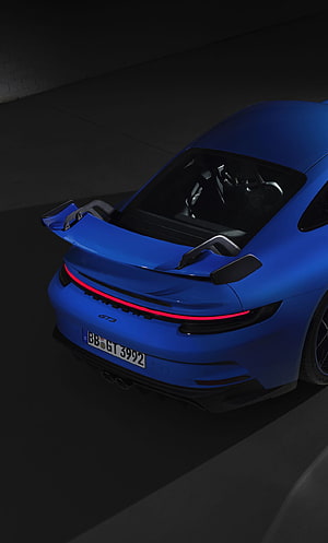 Rear View of a Blue Porsche 911 GT3 with Prominent Spoiler and LED Taillights in a Dark Studio Setting HD phone wallpaper