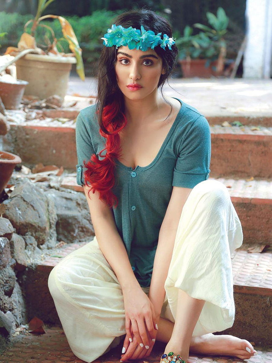 Adah Sharma in teal top and floral crown sitting in a garden HD phone wallpaper