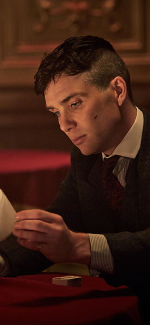Cillian Murphy as Tommy Shelby in Peaky Blinders at a dimly lit table with a matchbox HD phone wallpaper