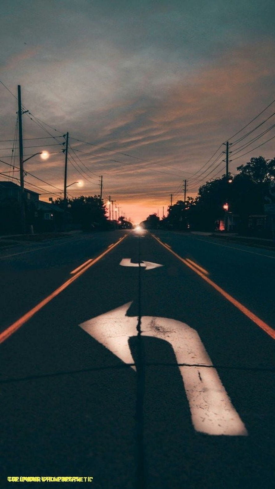 Moody Suburban Road at Dusk with Directional Arrows and Warm Sunset Sky HD phone wallpaper