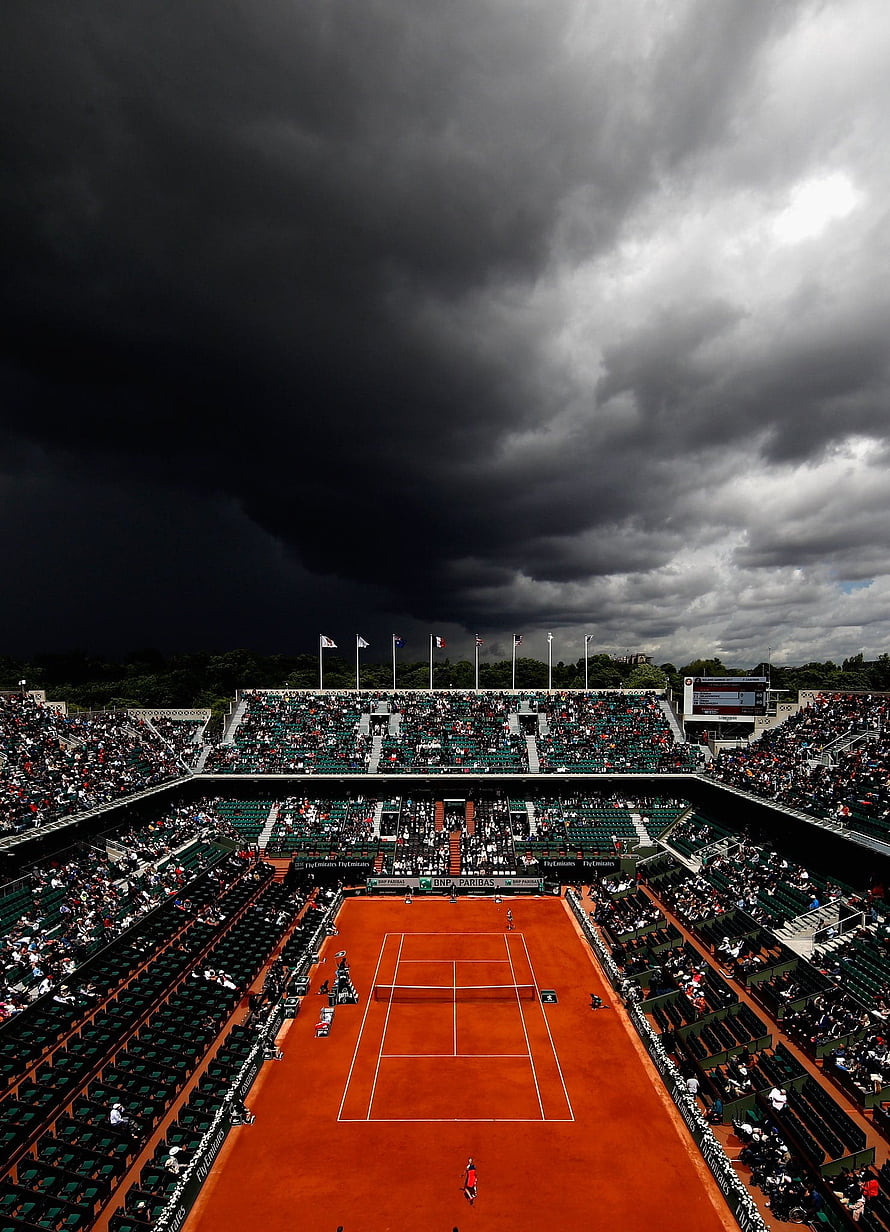 Dramatic Storm Clouds Over a Packed Clay Tennis Court at Roland Garros HD phone wallpaper