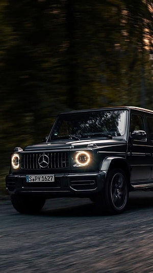 Black Mercedes-Benz G-Class SUV Driving on a Forest Road at Dusk HD phone wallpaper