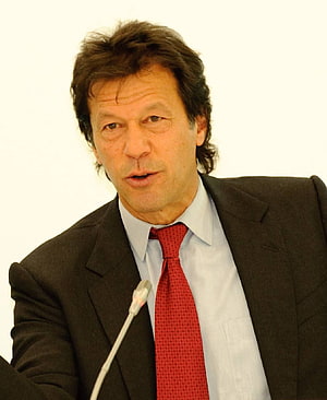 Imran Khan Speaking at a Formal Press Conference in a Dark Suit and Red Tie HD phone wallpaper
