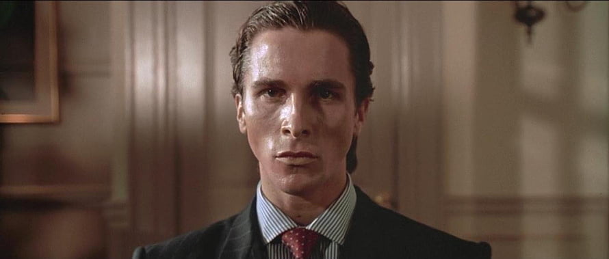 Patrick Bateman in a dark suit and red tie from the film American Psycho HD wallpaper