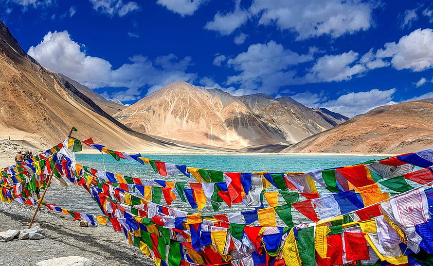 Colorful Tibetan Prayer Flags Draping Over a Turquoise Lake in the Leh Ladakh Himalayas HD wallpaper
