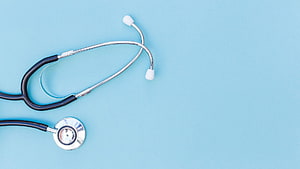Minimalist Medical Stethoscope on Light Blue Background for Healthcare Presentation HD wallpaper