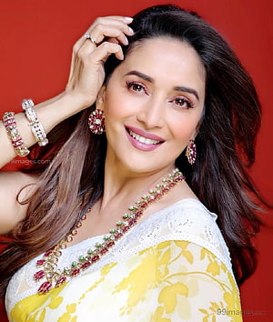 Madhuri Dixit in a yellow and white sari with traditional Indian jewelry against a red background HD phone wallpaper