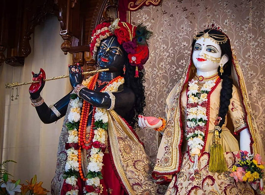 Radha Krishna Temple Deities Adorned in Traditional Garments and Floral Garlands HD wallpaper