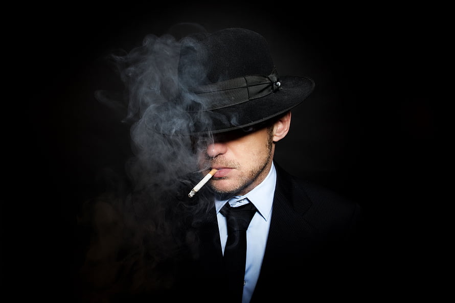 Mysterious Man in Black Fedora Smoking Cigarette Against Dark Background HD wallpaper