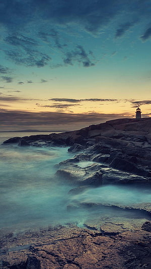 Lighthouse on Rocky Coast at Dusk with Long Exposure Misty Waves HD phone wallpaper