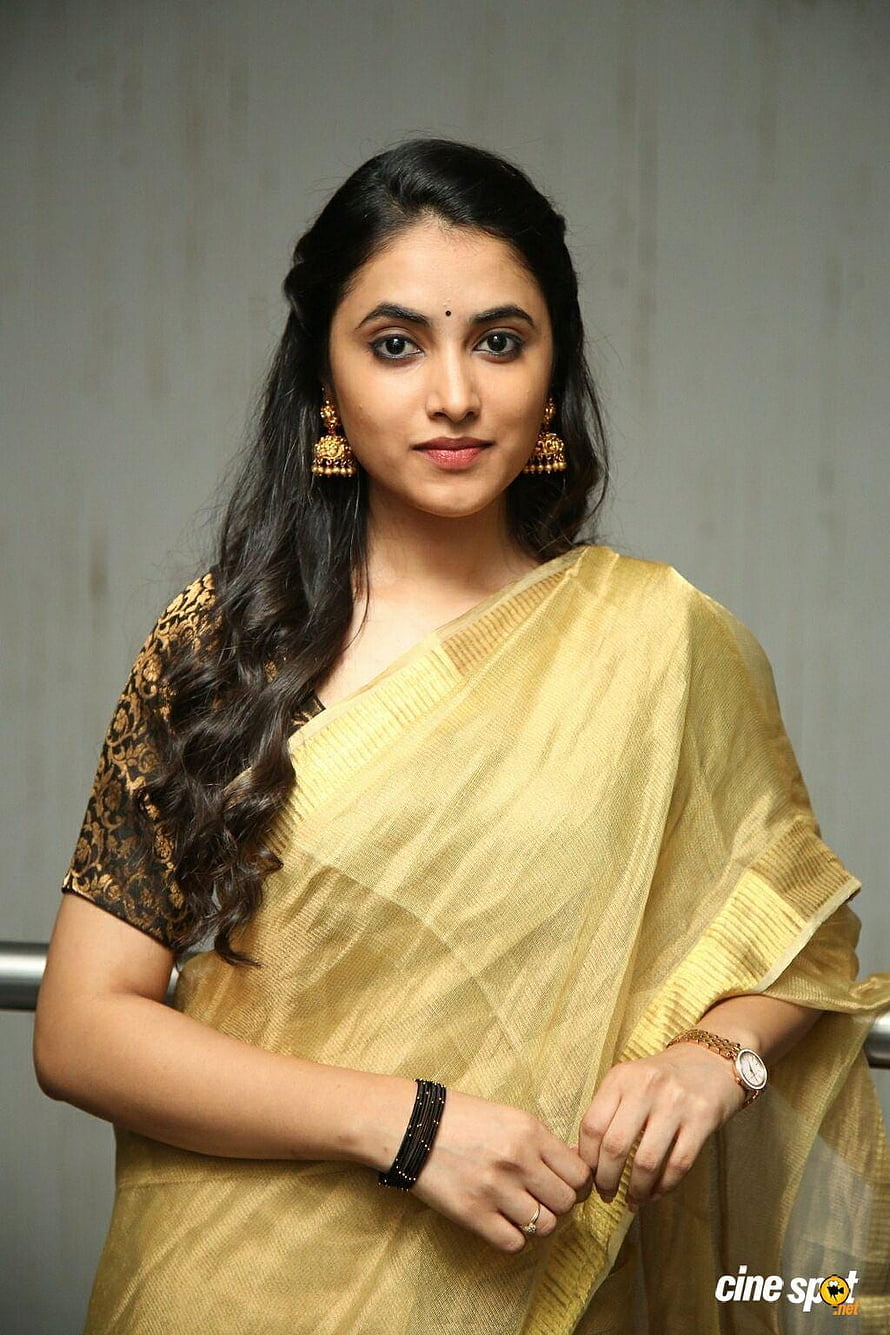 Priyanka Arul Mohan in a golden saree with traditional gold jewelry and long wavy hair HD phone wallpaper