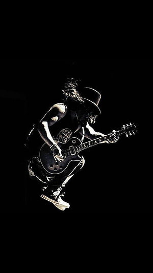 Slash from Guns N' Roses mid-air jump with electric guitar on dark stage HD phone wallpaper