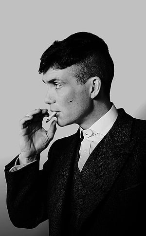Cillian Murphy in a three-piece suit holding a cigarette in a black and white profile portrait HD phone wallpaper