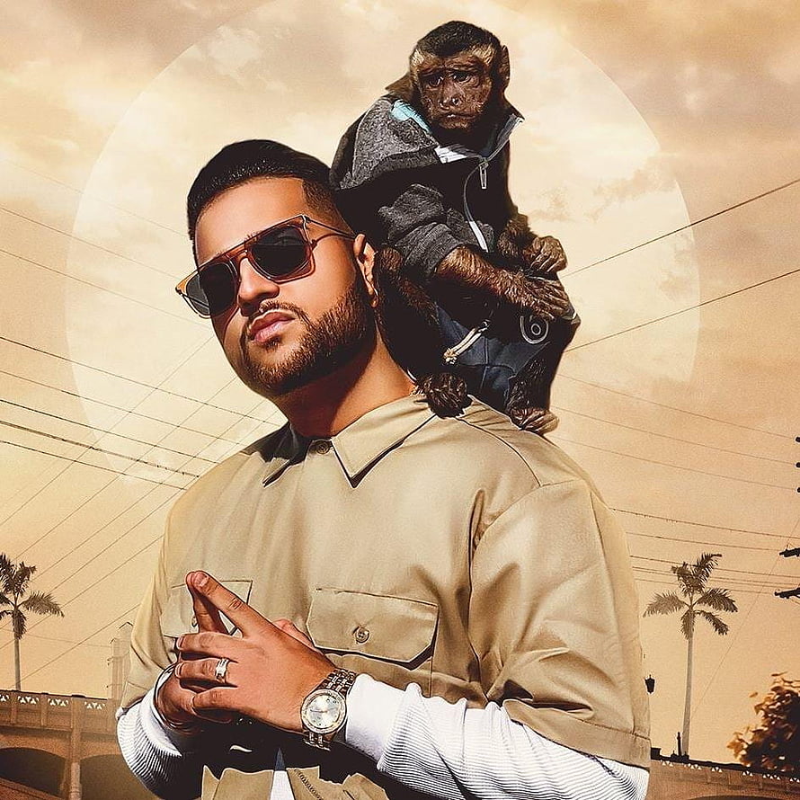 Karan Aujla with a chimpanzee on his shoulders against a golden sky backdrop HD phone wallpaper