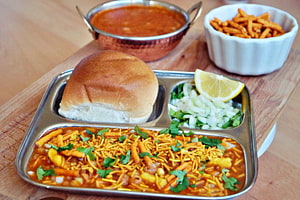 Traditional Misal Pav with Pav Bhaji, Fresh Onion, Coriander, and Lemon on a Steel Thali HD wallpaper