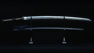 Traditional Japanese Katana Sword Displayed on Stand with Sheath Against Dark Background HD wallpaper
