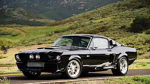 Black Classic Ford Mustang Fastback on Scenic Mountain Road HD wallpaper