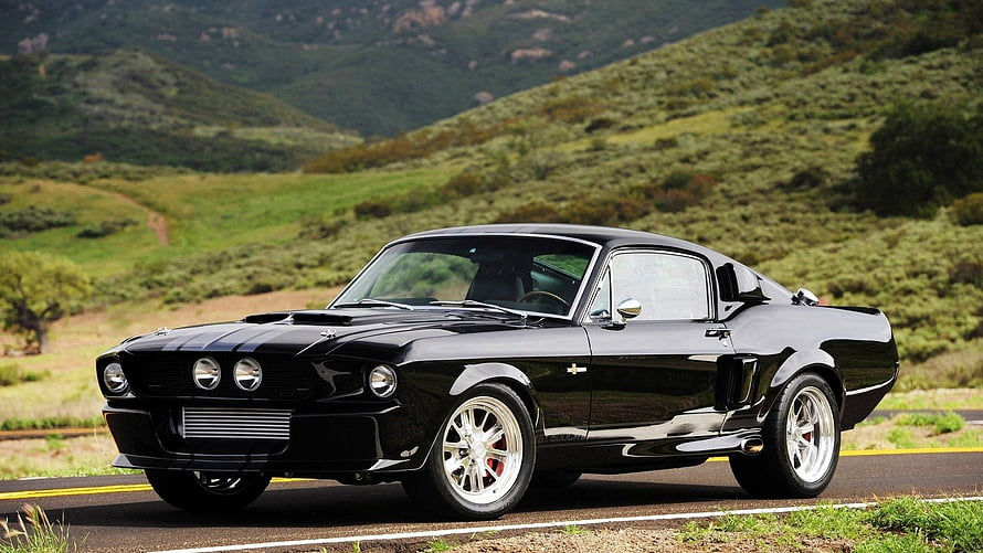 Black Classic Ford Mustang Fastback on Scenic Mountain Road HD wallpaper
