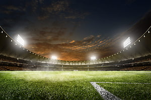 Floodlit Soccer Stadium at Dusk with Dramatic Sunset Sky and Empty Green Pitch HD wallpaper