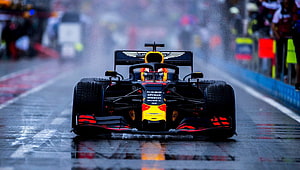 Red Bull Racing Formula 1 car driving on a wet track in the rain HD wallpaper