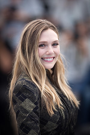 Elizabeth Olsen smiling portrait in a black and gold patterned dress at a public event HD phone wallpaper