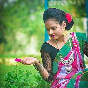 Santali woman in green and pink sari holding a pink flower in a garden HD phone wallpaper