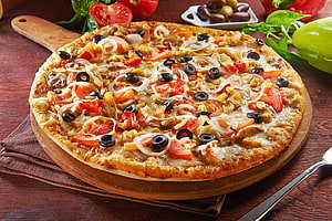 Rustic Vegetable Pizza With Olives, Tomatoes, and Onions on a Wooden Board HD wallpaper