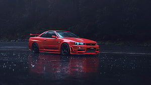 Red Nissan Skyline R34 GT-R parked on wet asphalt in the rain with dark forest background HD wallpaper