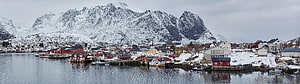 Snow-Covered Norwegian Fjord Village with Red Boathouses and Mountain Backdrop HD wallpaper