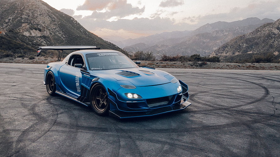 Blue Mazda RX-7 Widebody Drift Car on Mountain Asphalt at Sunset HD wallpaper