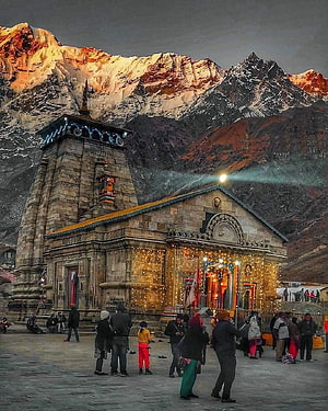Kedarnath Temple at Dusk with Snow-Capped Himalayan Peaks and Devotees in the Foreground HD phone wallpaper