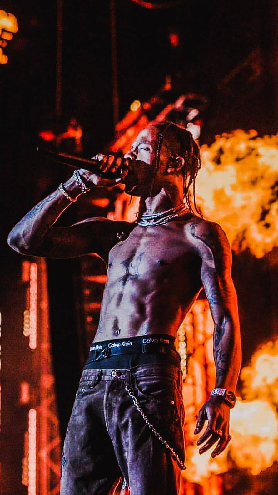 Travis Scott performing shirtless on stage with pyrotechnics and dramatic red lighting HD phone wallpaper