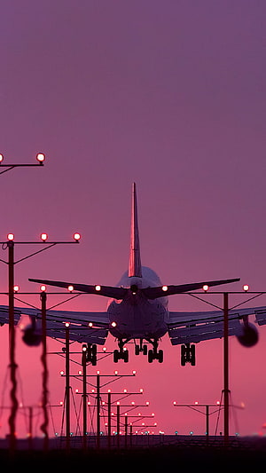 Commercial Jetliner Silhouette Approaching Runway at Dusk with Purple Sky HD phone wallpaper