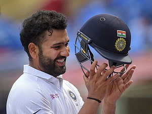 Virat Kohli smiling while holding an Indian cricket helmet in white Test kit HD wallpaper