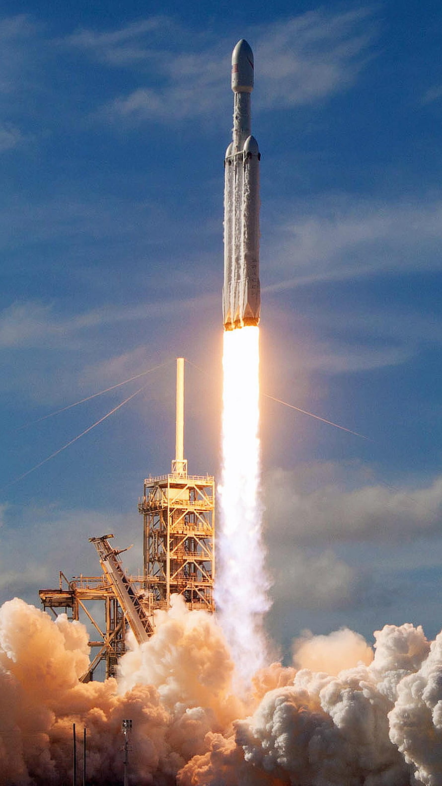 SpaceX Falcon Heavy rocket ascending from launch pad with intense flame and smoke HD phone wallpaper