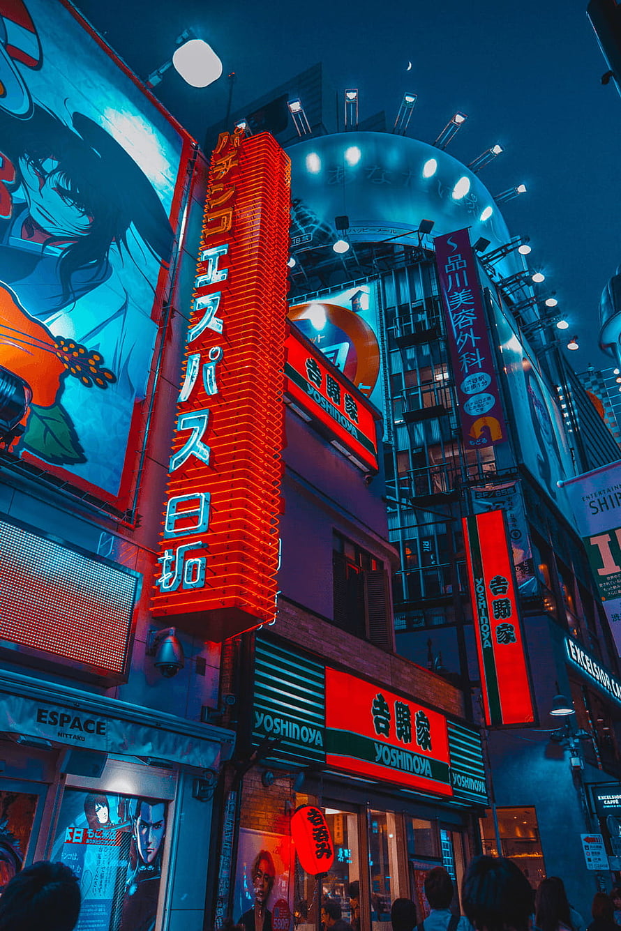 Neon-lit Tokyo street at night with glowing red and blue signs and anime billboard HD phone wallpaper