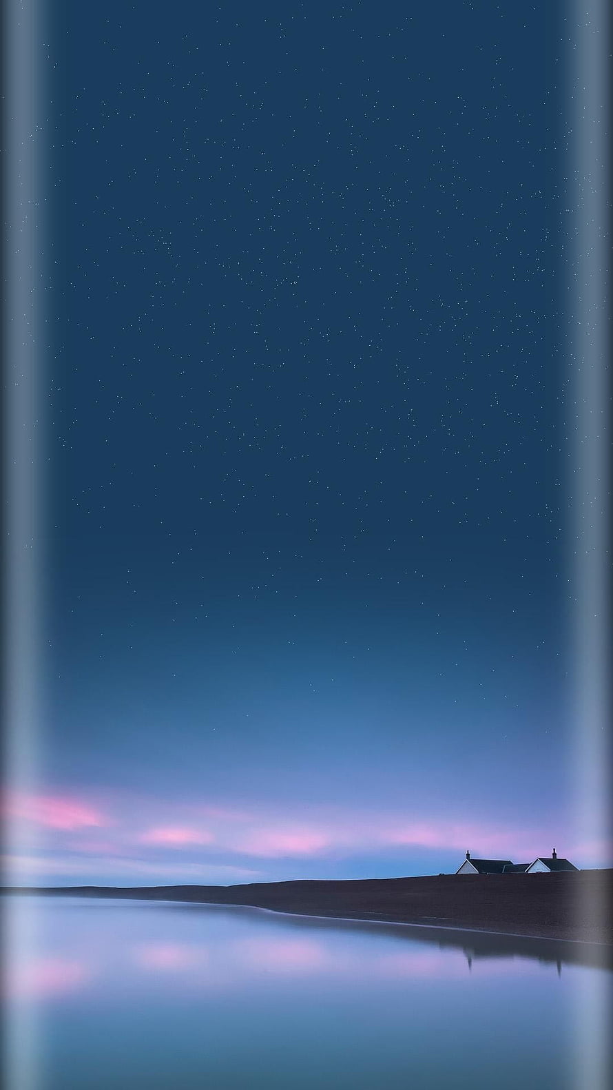 Serene Starry Night Sky Over Calm Water with Distant Houses and Pink Horizon Glow HD phone wallpaper