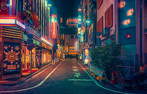 Neon-lit Japanese alleyway at night with glowing signs and brick pavement HD wallpaper