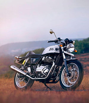 Royal Enfield Continental GT 650 parked on a scenic hillside at dusk HD phone wallpaper
