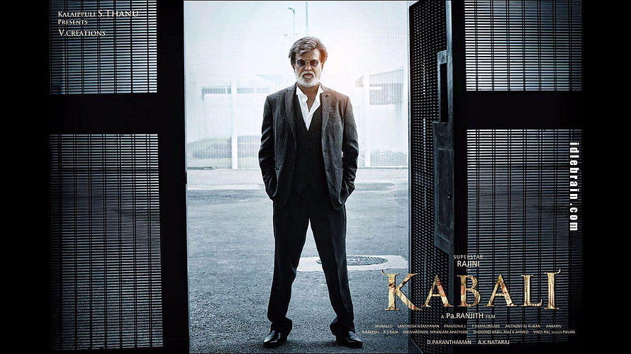 Rajinikanth in a dark suit standing in a doorway from the movie Kabali HD wallpaper