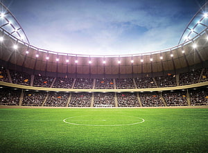 Vast Football Stadium Interior With Packed Stands And Floodlit Pitch HD wallpaper